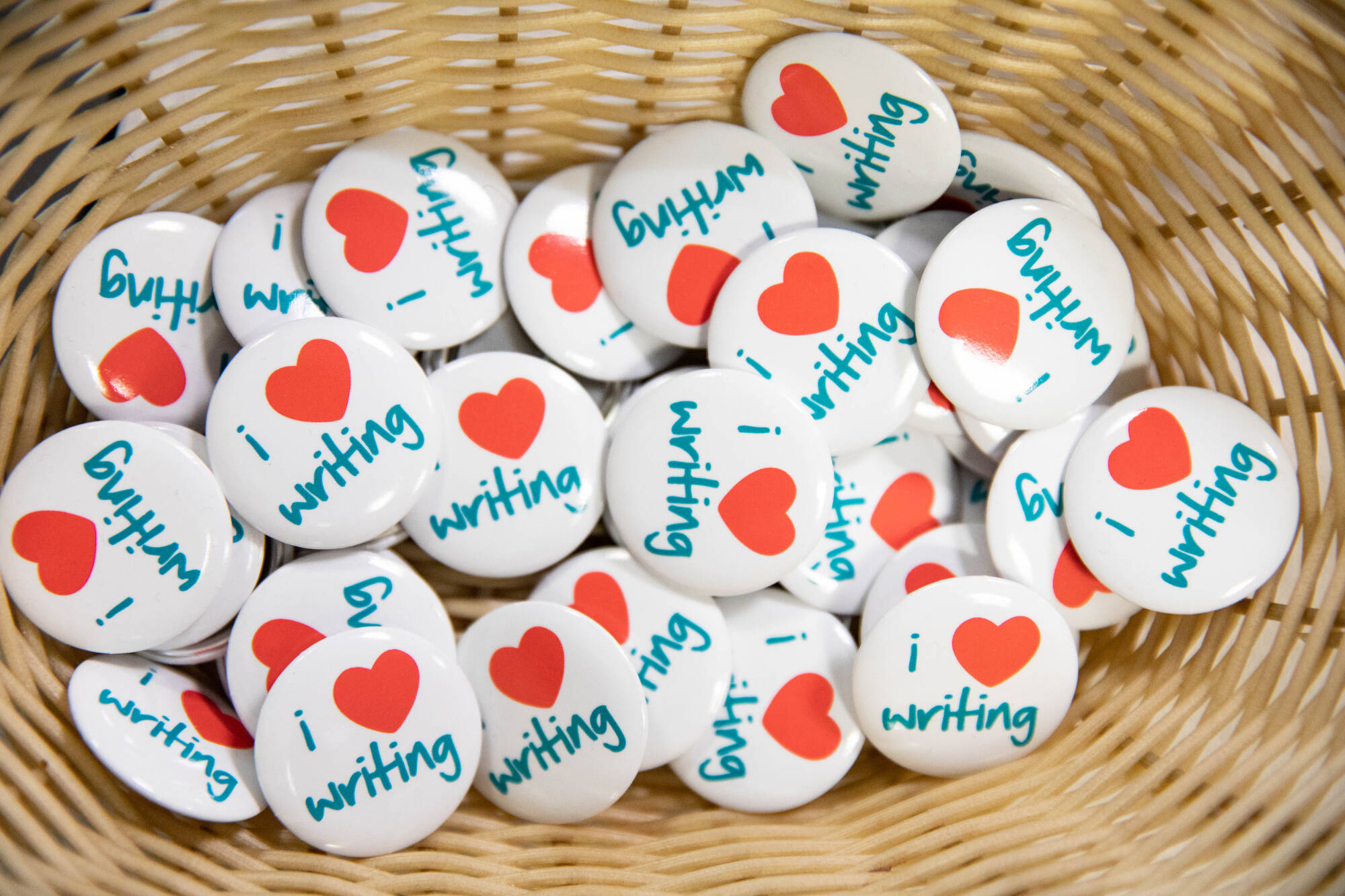 bowl containing pins that say I heart writing